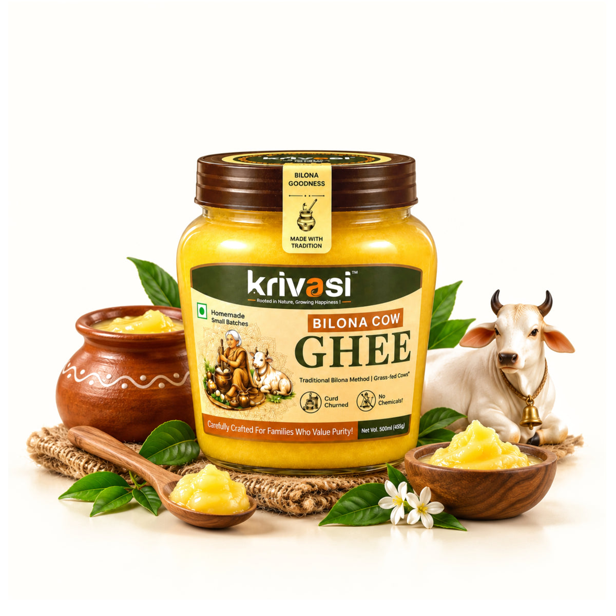 A jar of Krivasi Bilona Cow Ghee is centered on a white background, surrounded by decorative props including small bowls of yellow ghee, a wooden spoon, green leaves, and a white cow figurine. The product label is clearly visible, showing the brand name 'krivasi' and the variant 'Bilona Cow Ghee'.